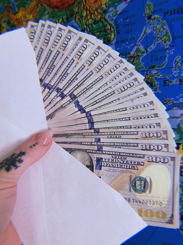 Hand holding envelope full of cash